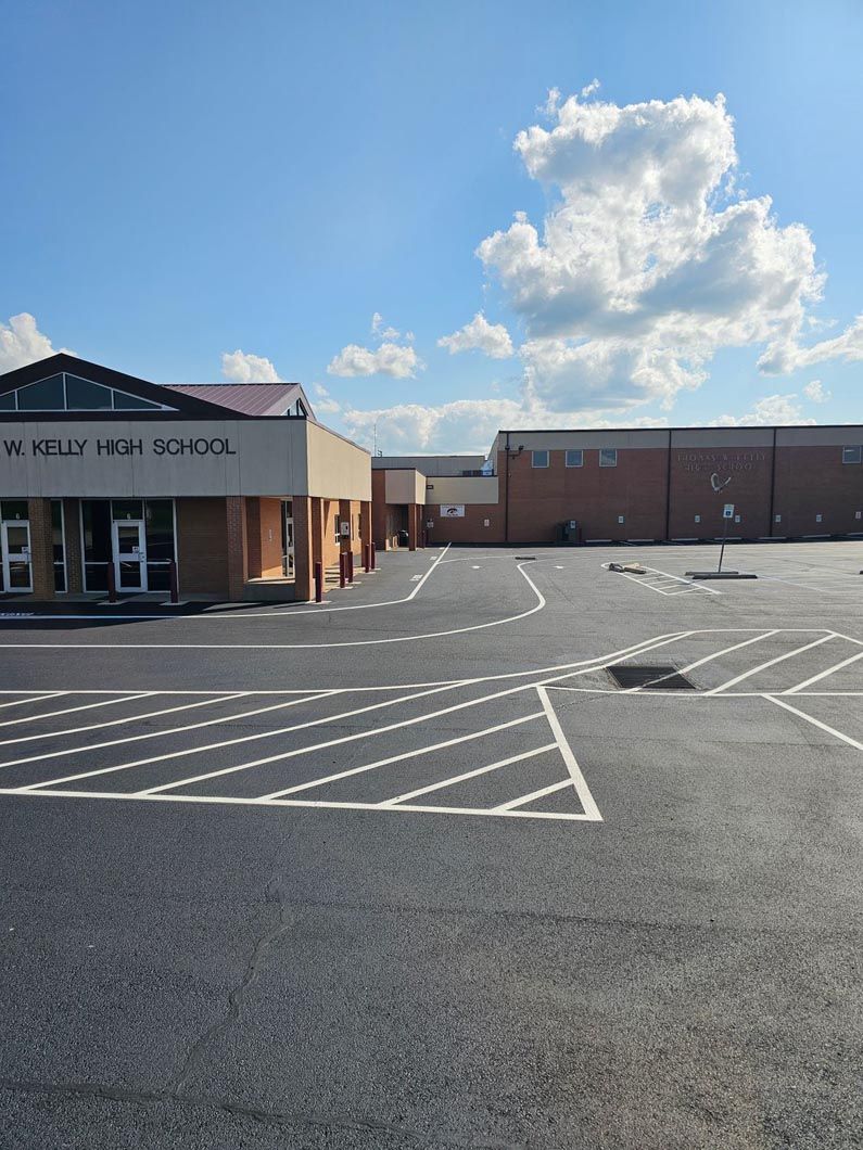 A large brick building with a parking lot in front of it.