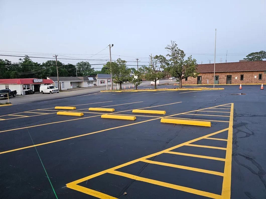 A parking lot with yellow lines and a building in the background