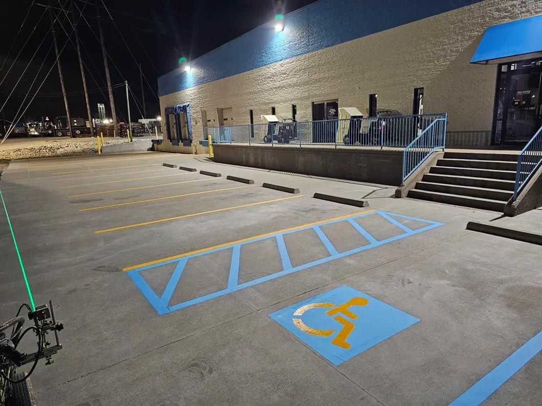 A handicapped parking spot is painted on the ground in front of a building.