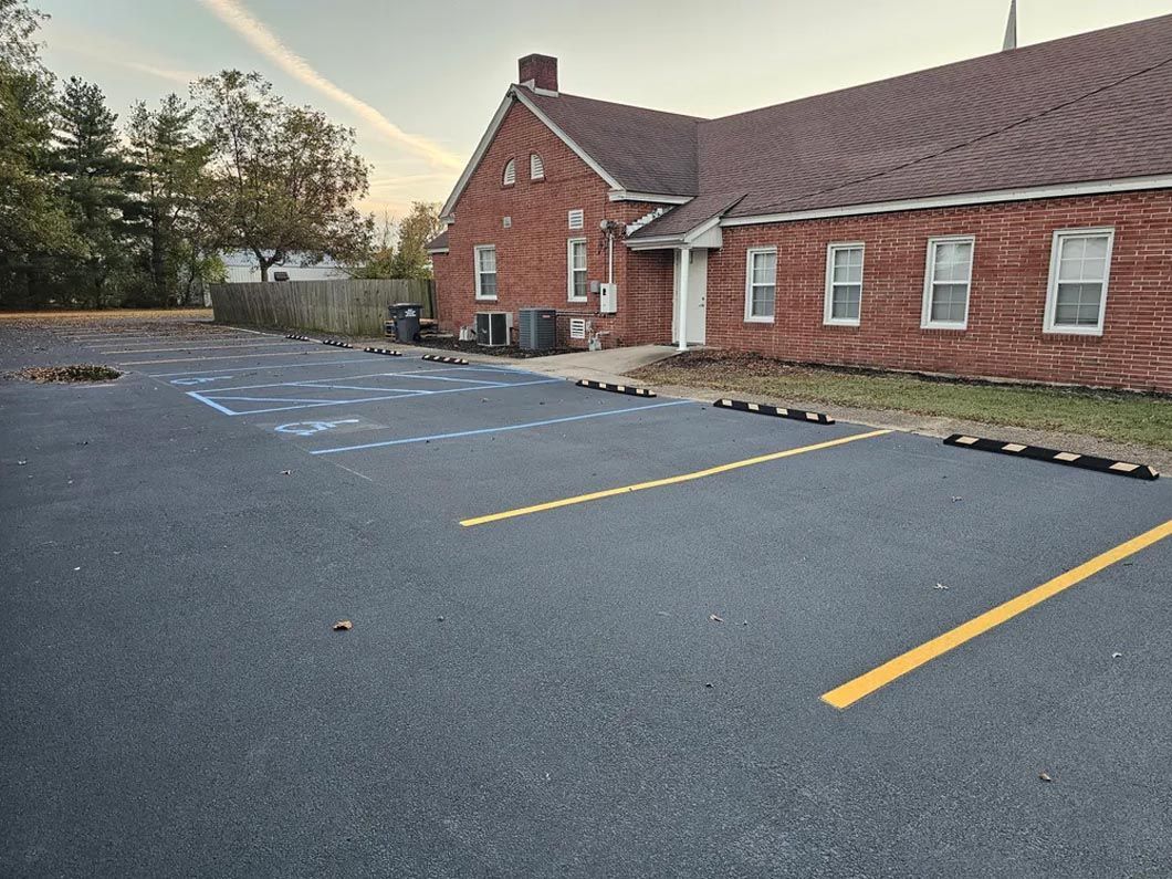 A brick building with a parking lot in front of it