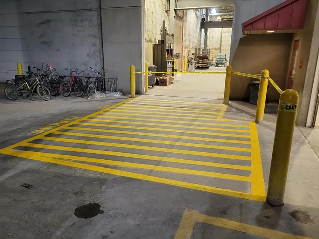A row of bikes are parked in a parking lot next to a ramp.