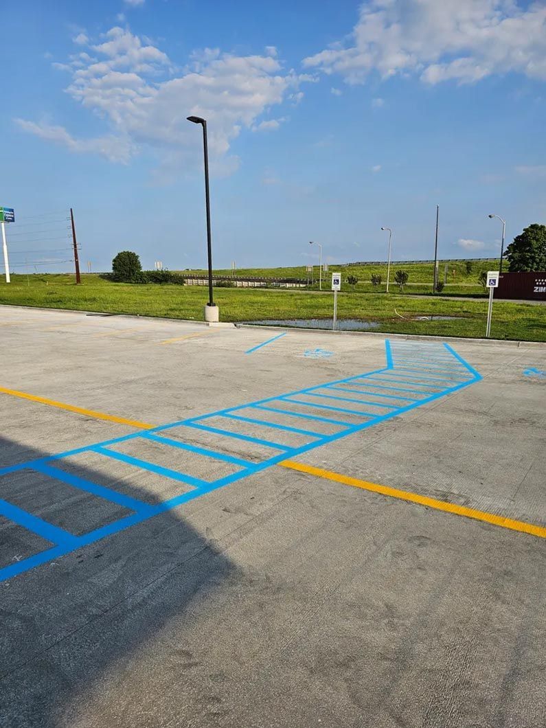 A parking lot with a handicapped parking spot painted blue and yellow.