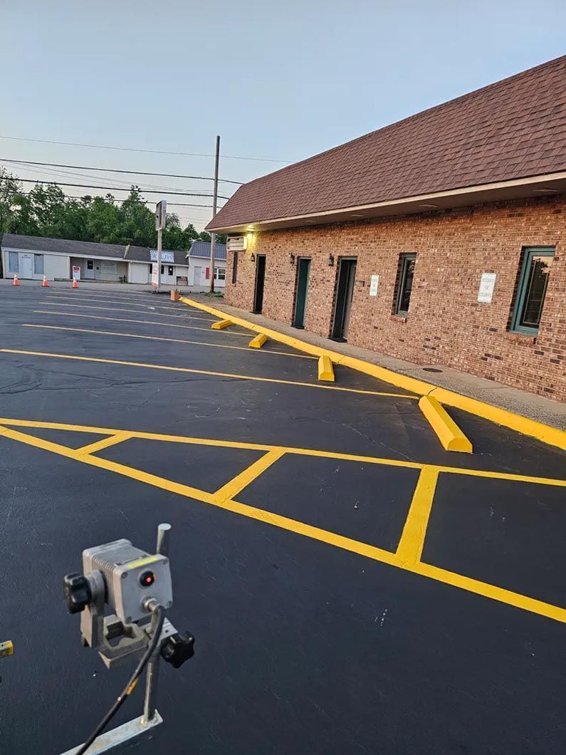A camera is sitting in a parking lot in front of a brick building.
