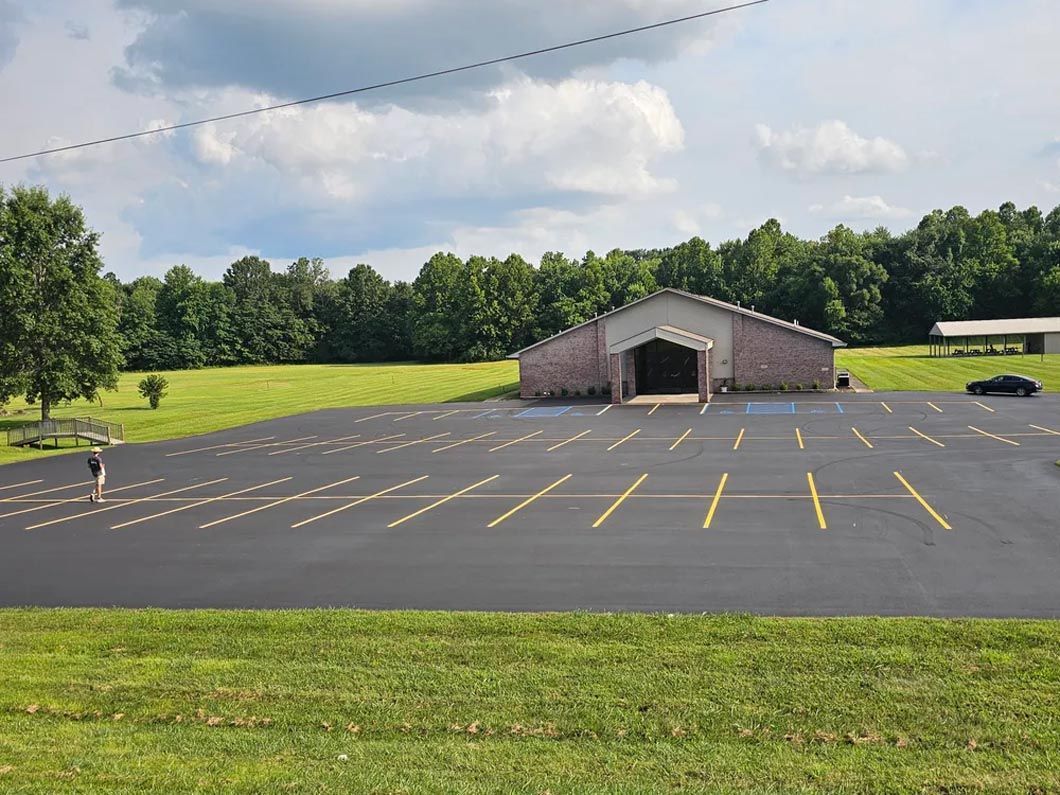 There is a large building in the middle of a parking lot.