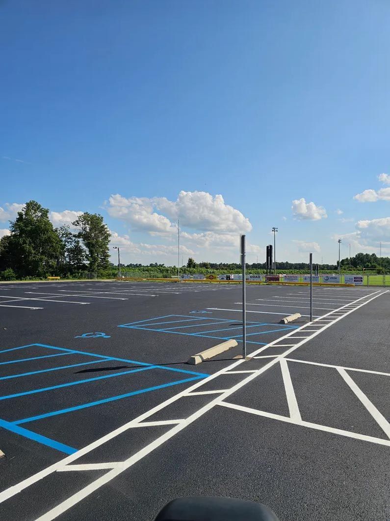 A parking lot with blue and white lines and a blue sky in the background