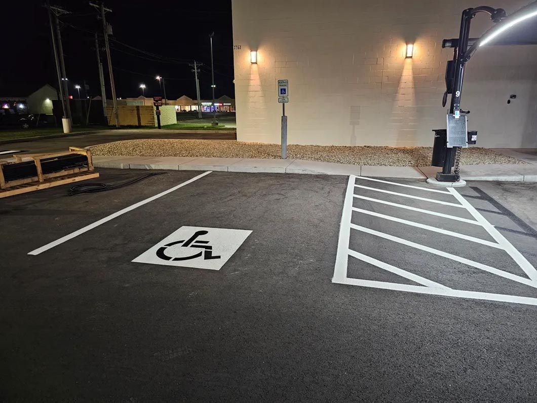 A parking lot with a handicap sign painted on the ground.