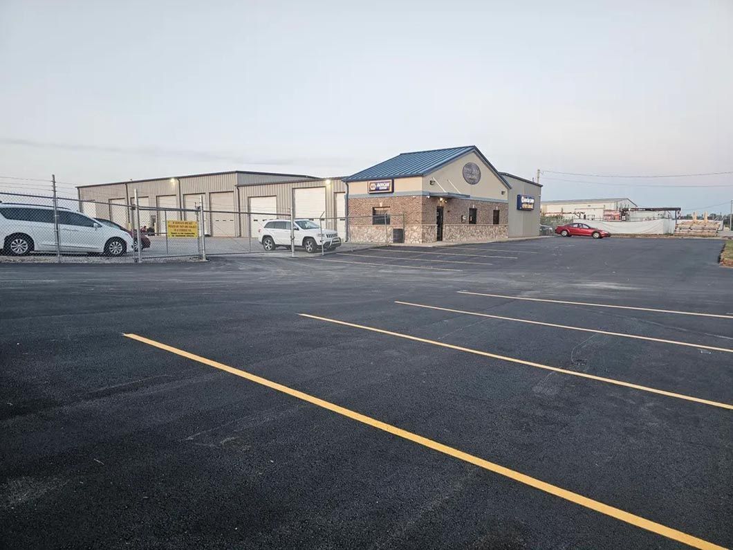 A parking lot with cars parked in front of a building.