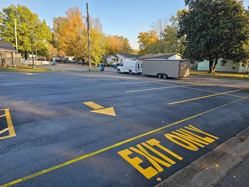 A yellow exit only sign is painted on the side of the road.