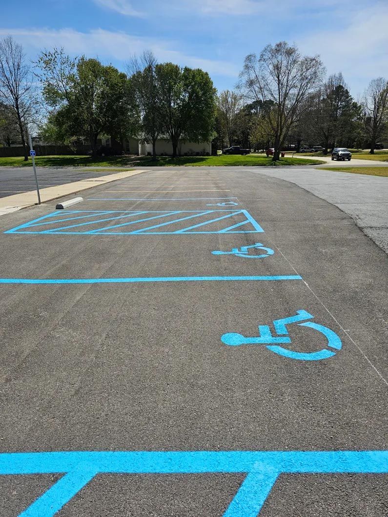 A handicapped parking spot is painted blue in a parking lot