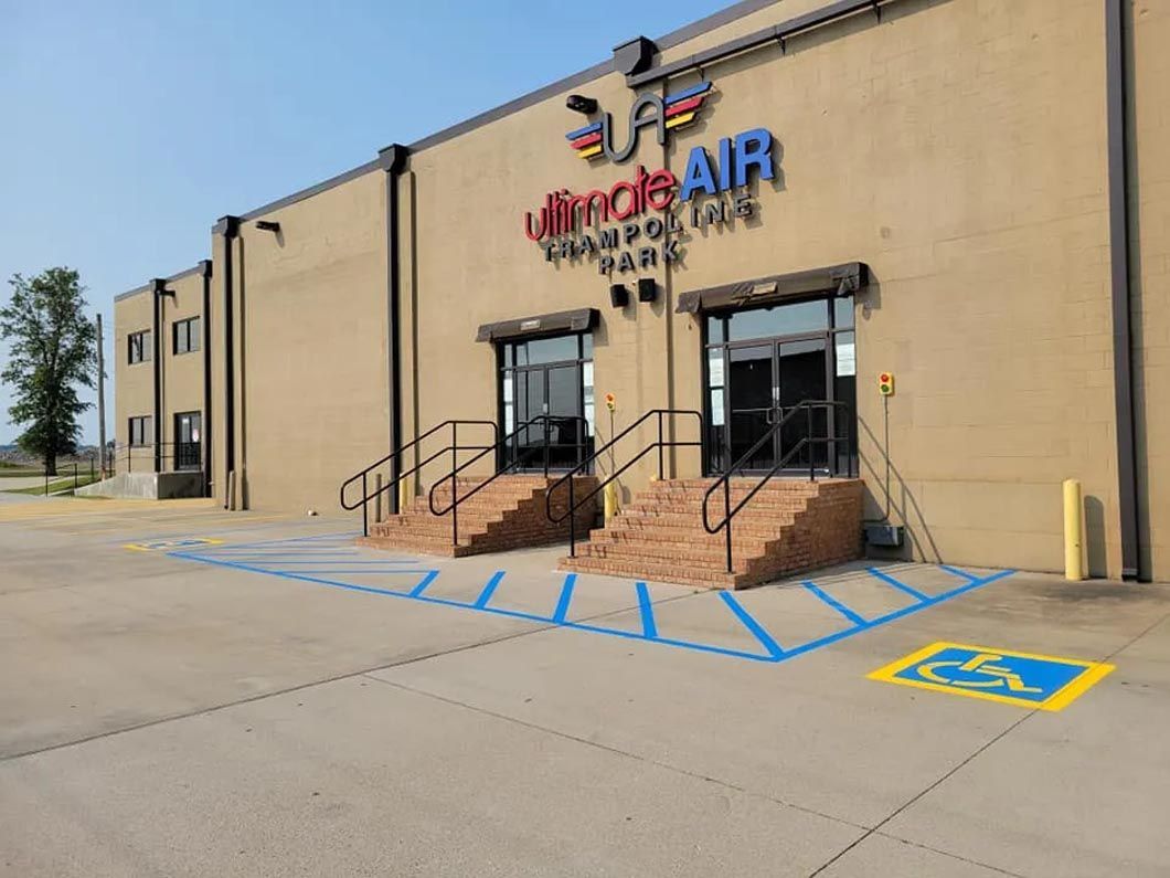 A large building with a handicapped parking spot in front of it.