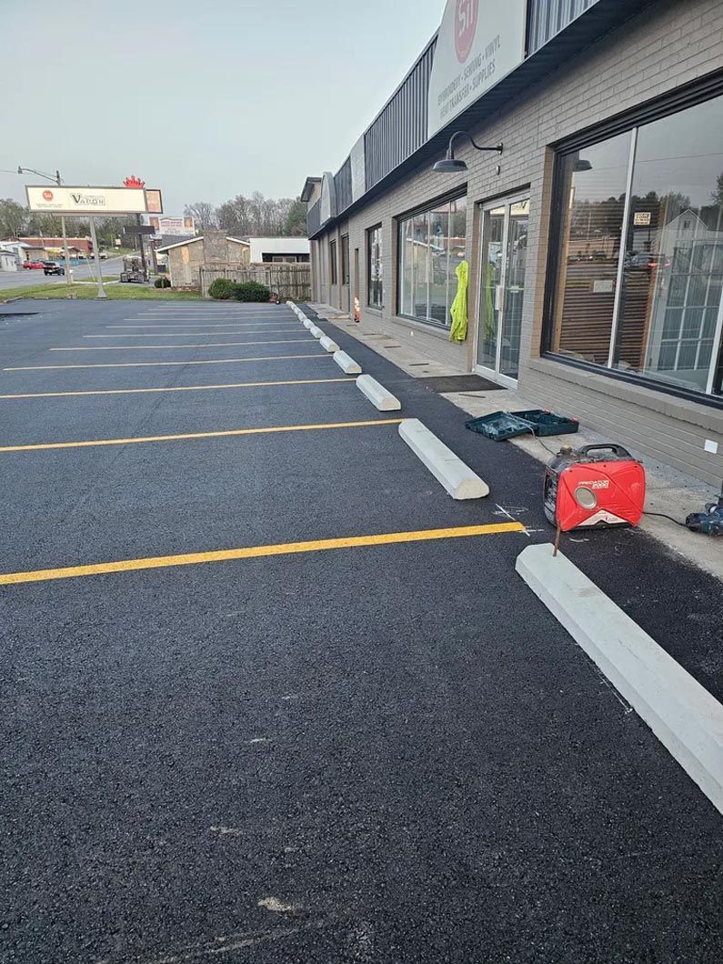 A parking lot in front of a building with a red bag on the ground.