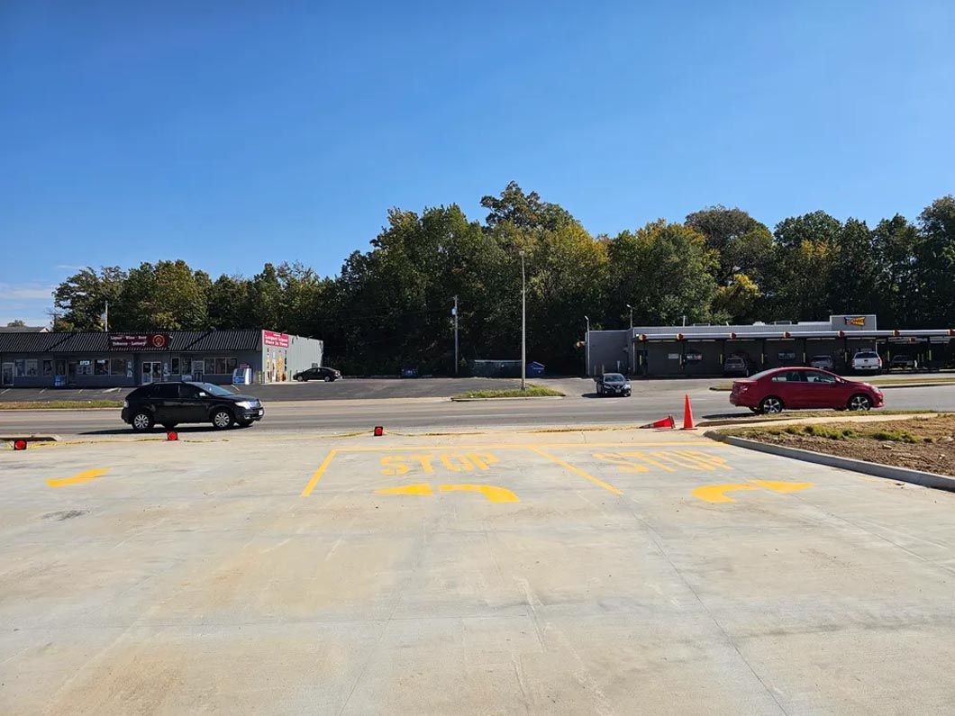 Two cars are parked in a parking lot in front of a building.