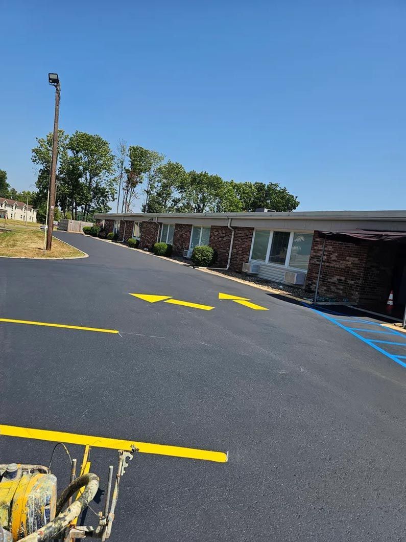 A parking lot is being painted yellow in front of a building.