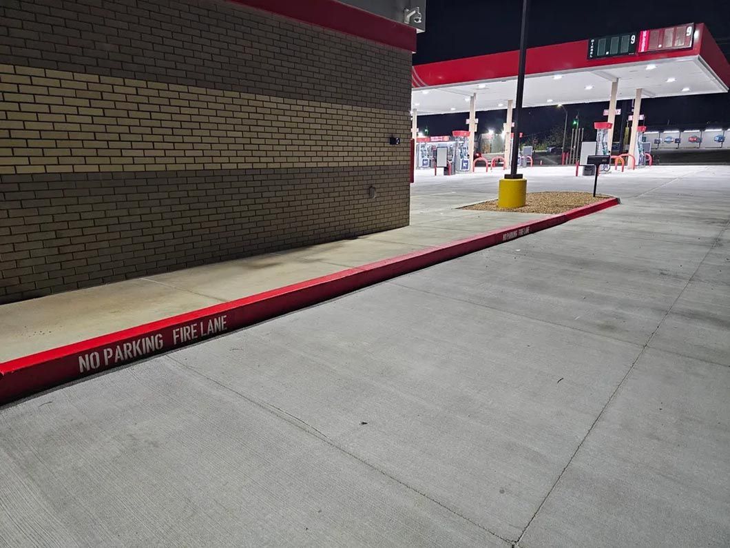 A gas station with a no parking sign on the sidewalk.