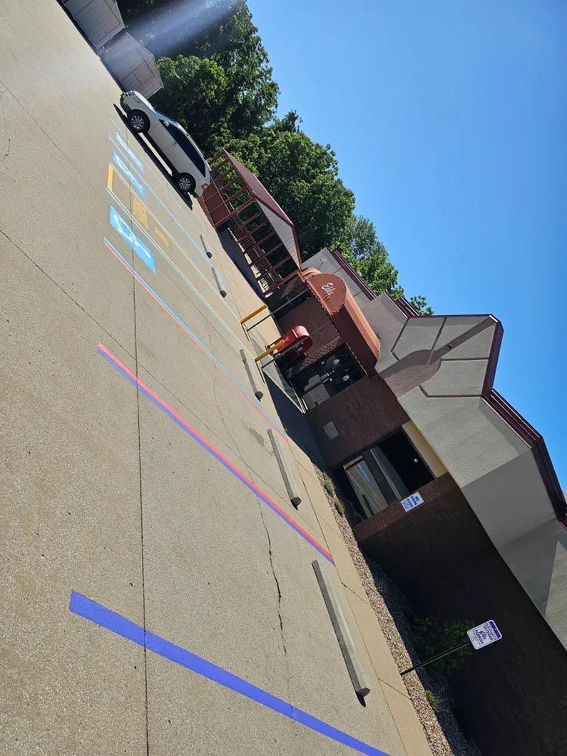 A car is parked in a parking lot next to a building.