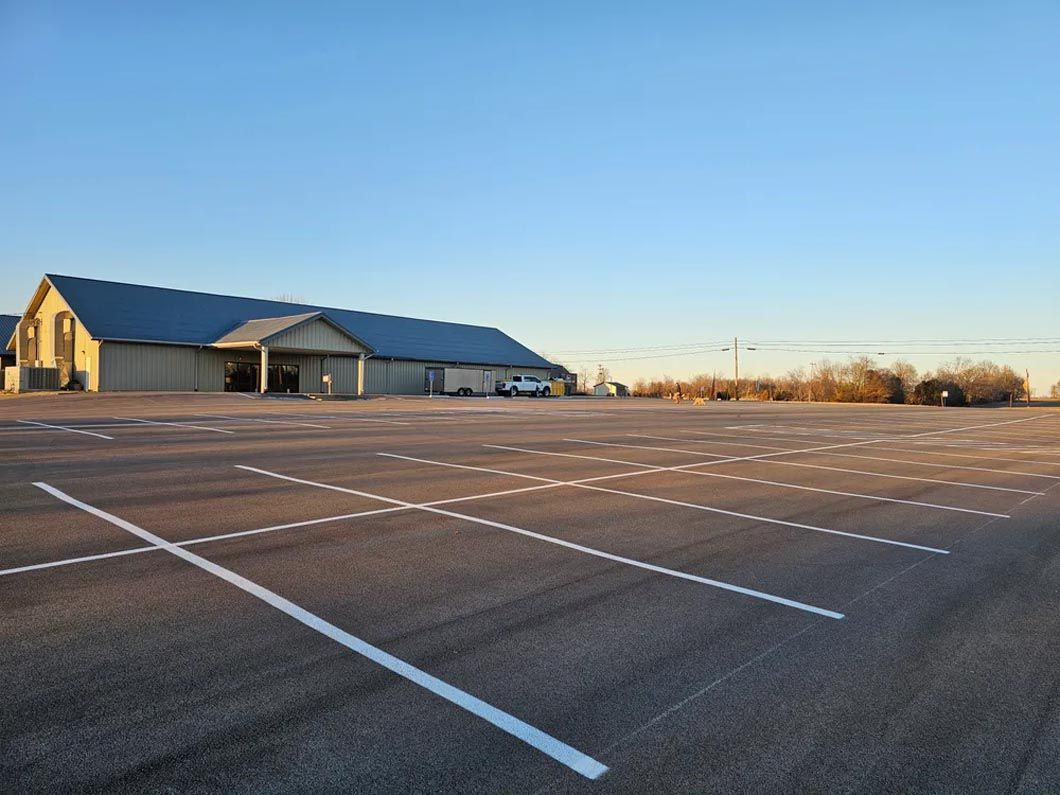 An empty parking lot with a building in the background.