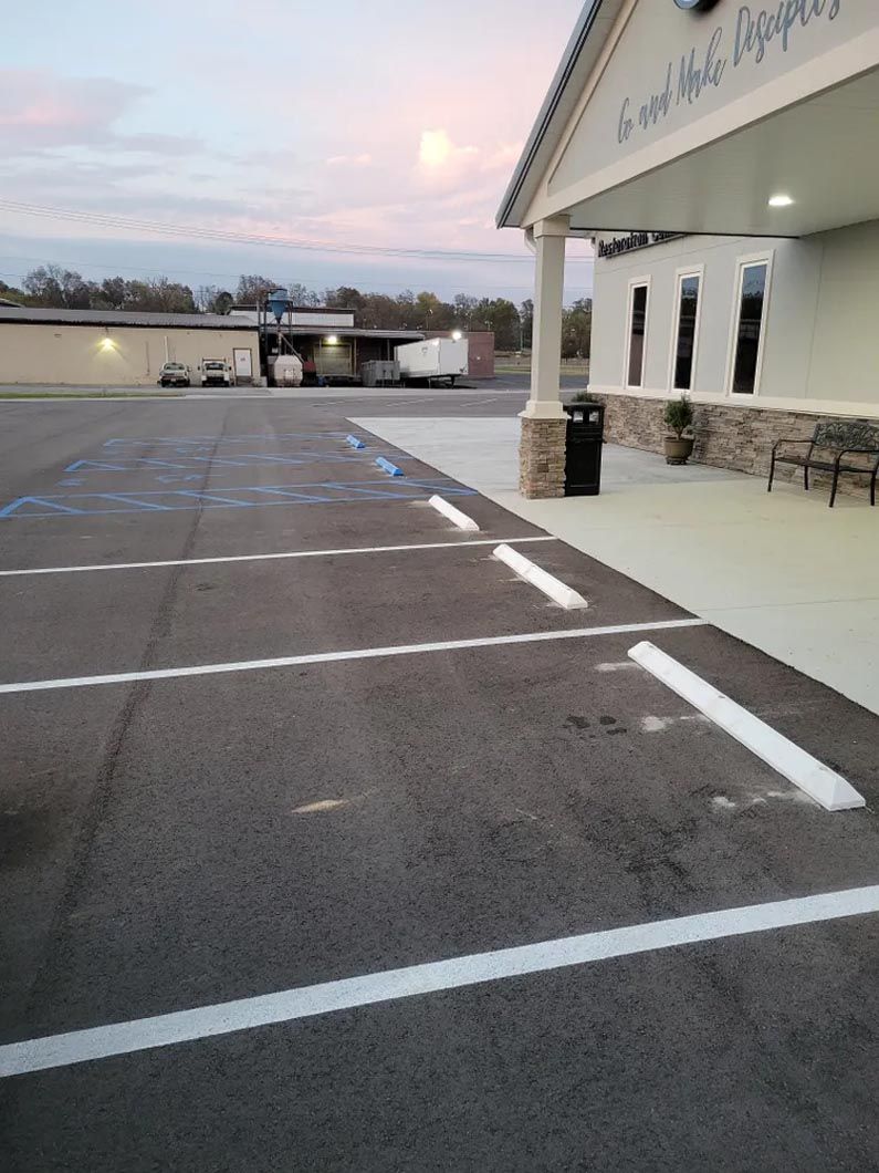 A parking lot with cars parked in front of a building.