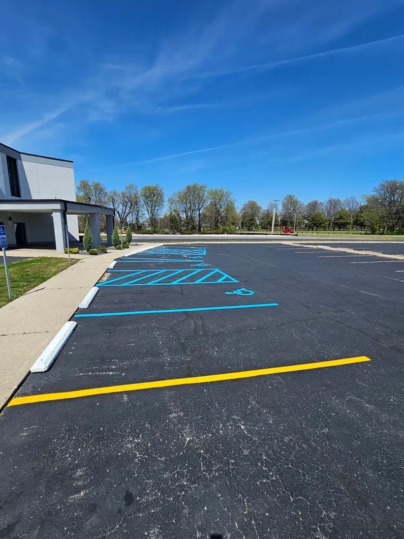 A parking lot with a handicapped parking spot and a yellow line.