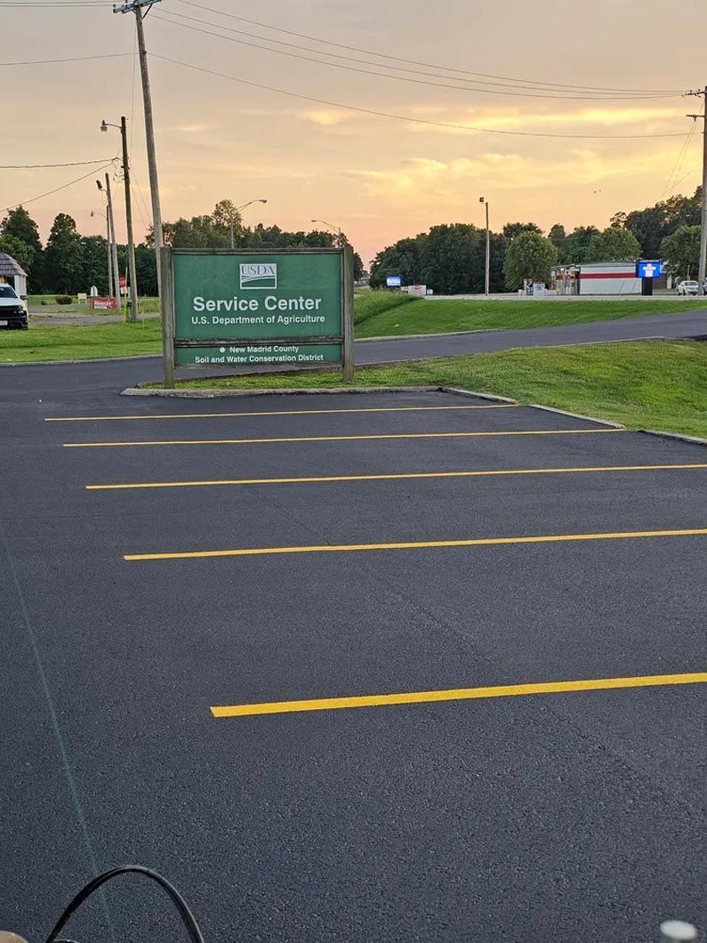 A parking lot with a green sign that says service center