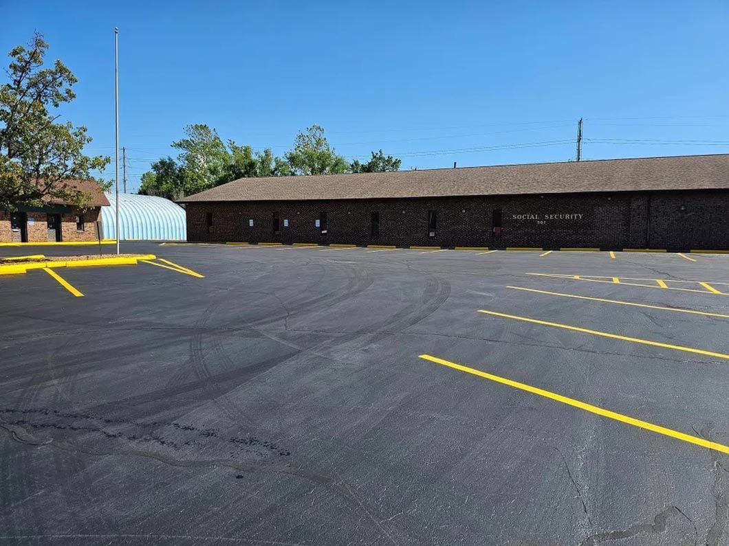 A large parking lot with a building in the background.
