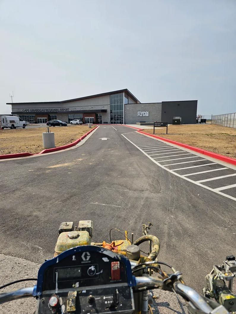 A motorcycle is parked on the side of the road in front of a building.