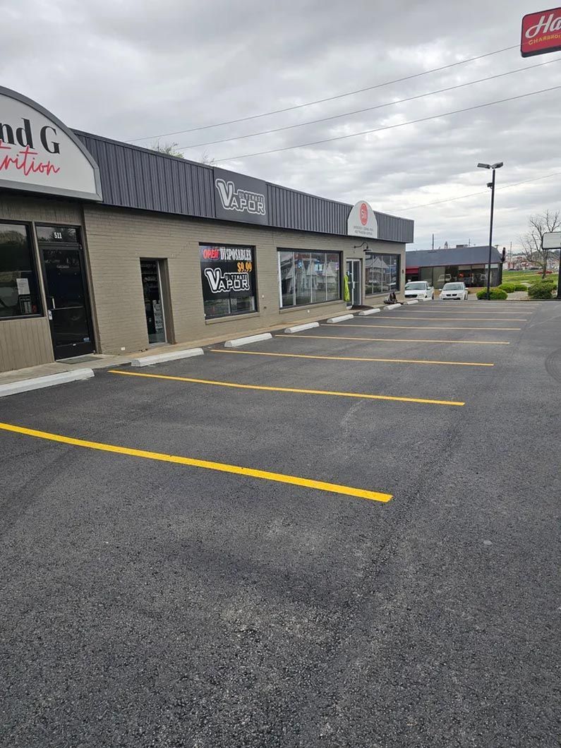 A parking lot in front of a building with a lot of parking spaces.