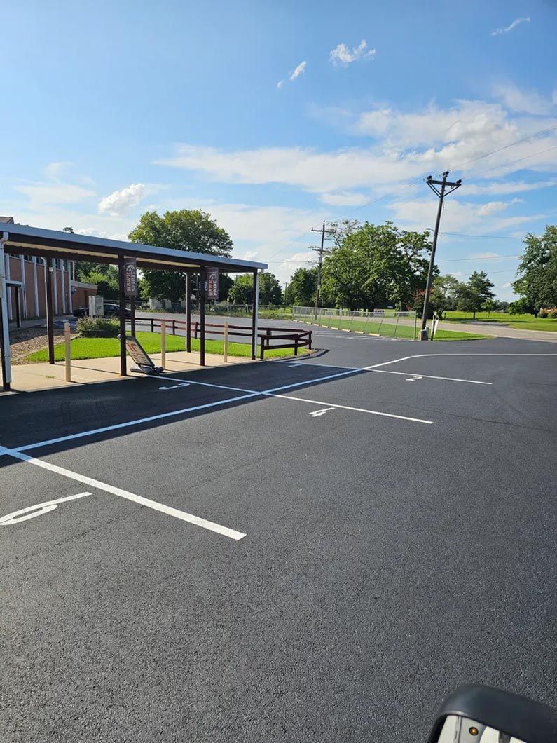 A parking lot with a picnic table and a building in the background