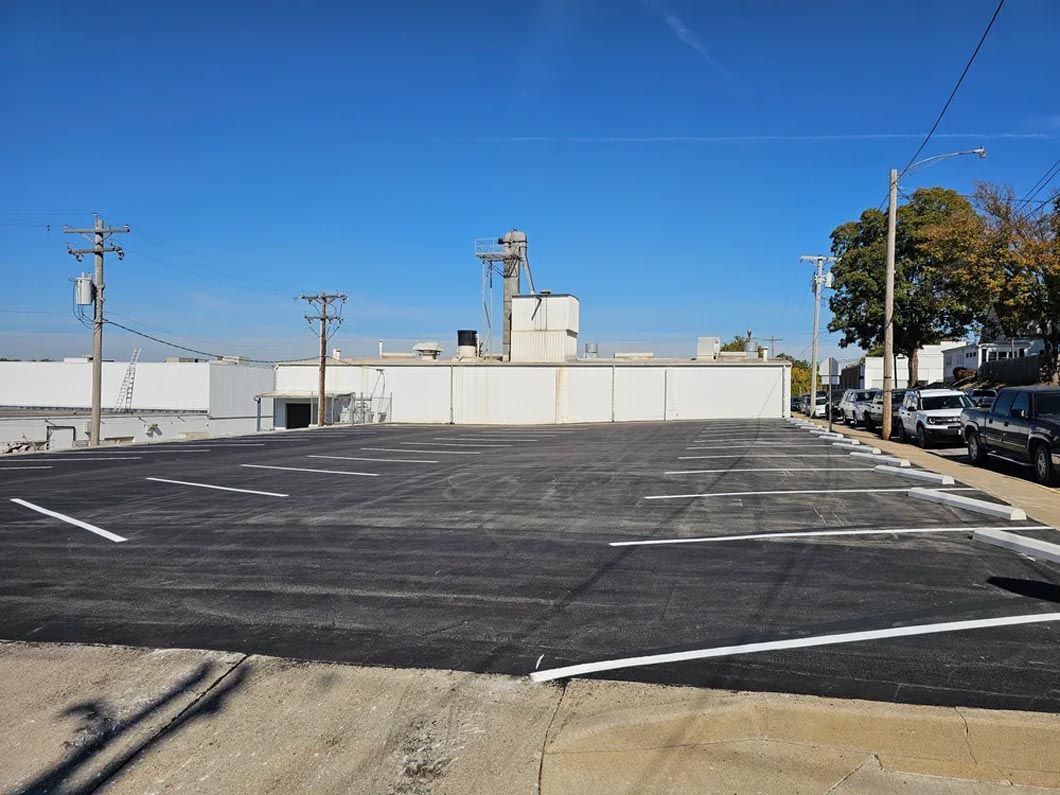 A parking lot with cars parked in front of a building on a sunny day.