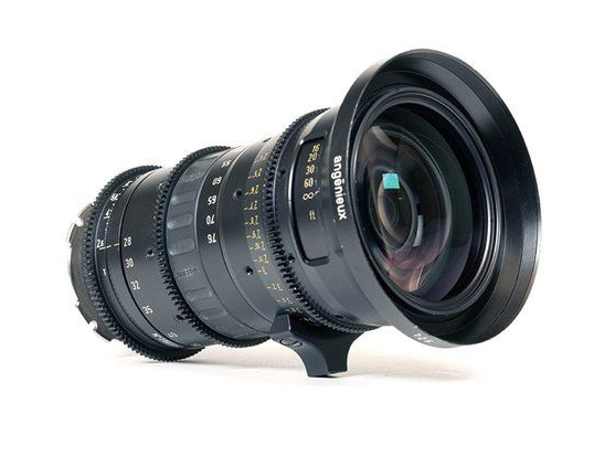 Black cinema lens with focus and iris rings, mounted on a white surface.