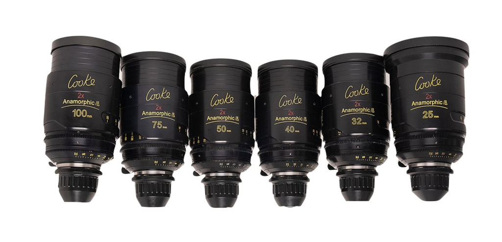 Six black cine lenses aligned. Each has a gold logo and focal length marking.