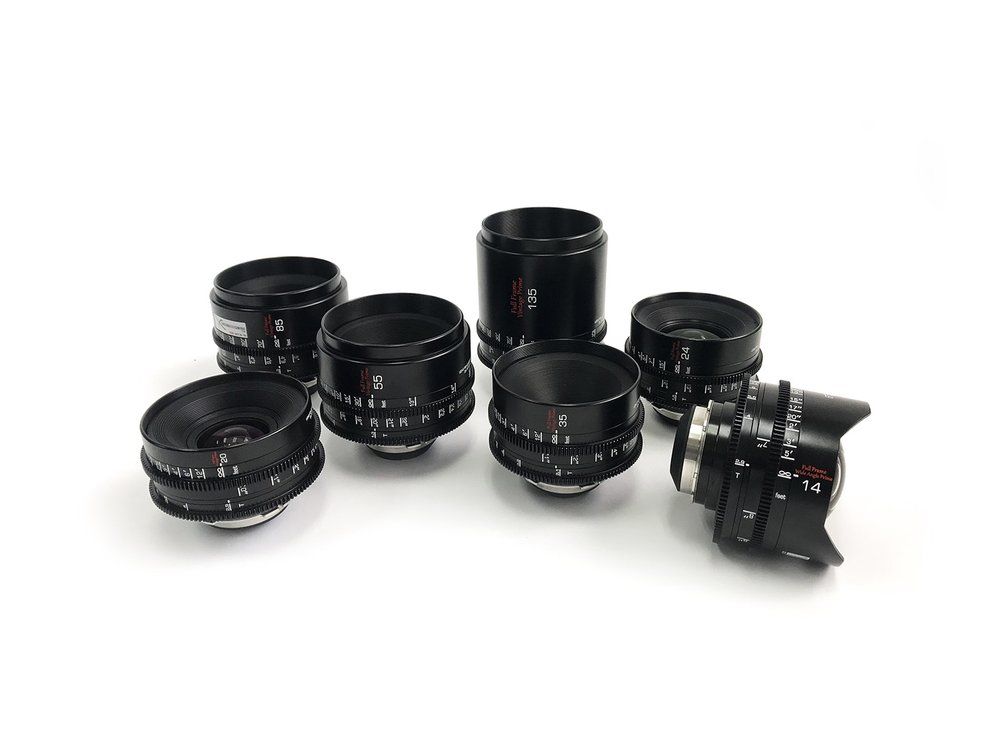 Seven black camera lenses on a white background.
