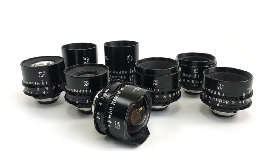 Black cinema lenses arranged on a white surface.