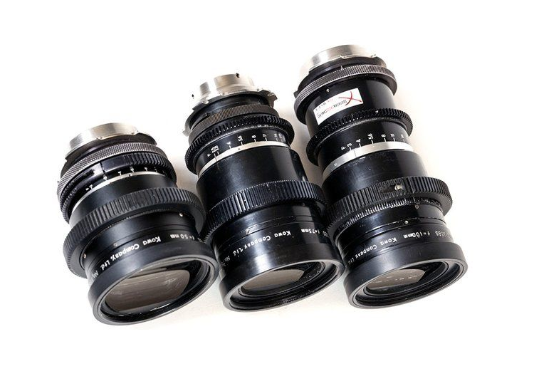 Three black camera lenses with silver mounts, on a white background.