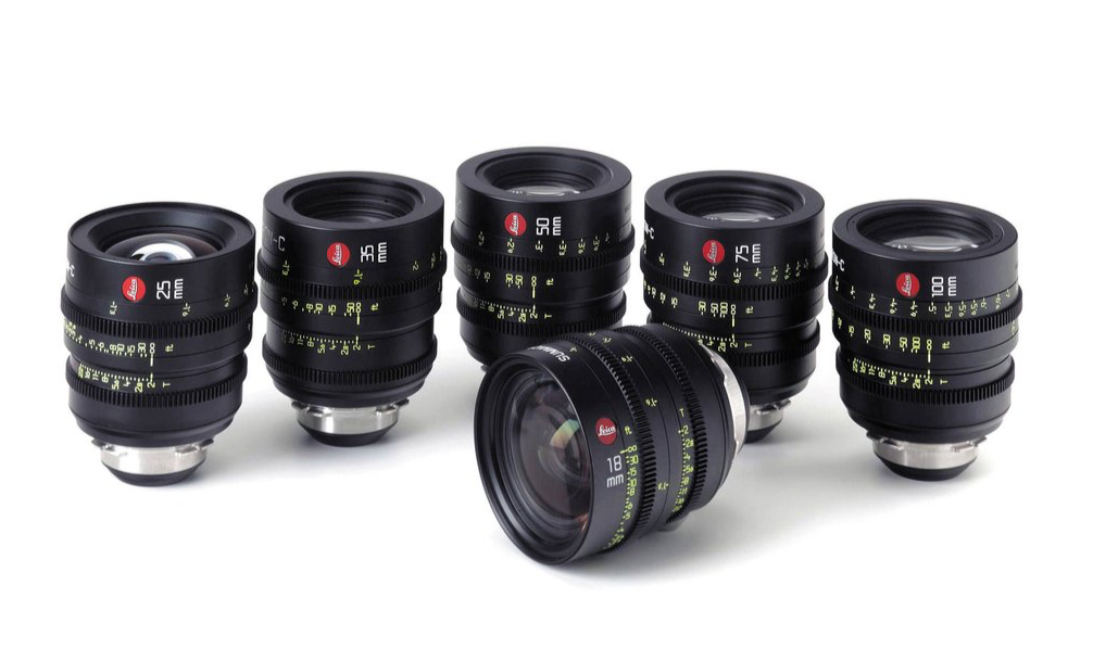 Five black camera lenses with red markings on a white background.