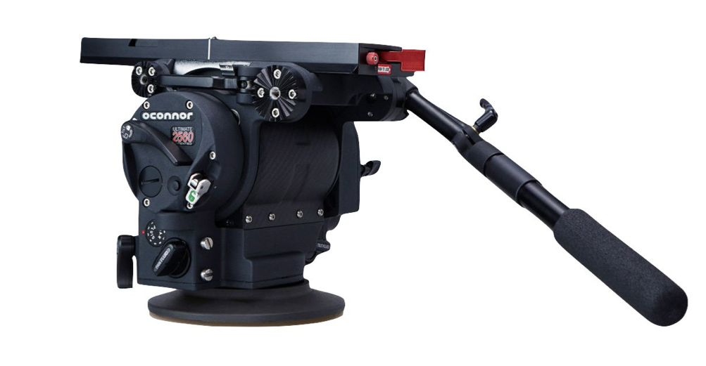 Black video camera tripod head with handle, knobs, and adjustment features.