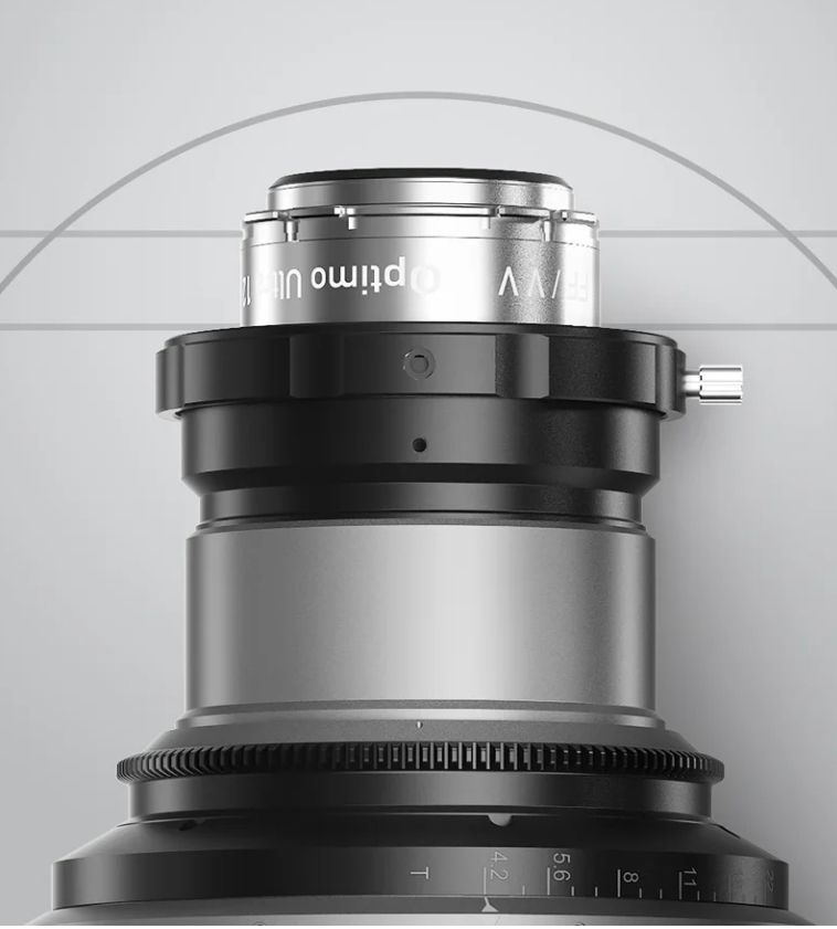 Close-up of a silver and black cine lens. The lens is labeled