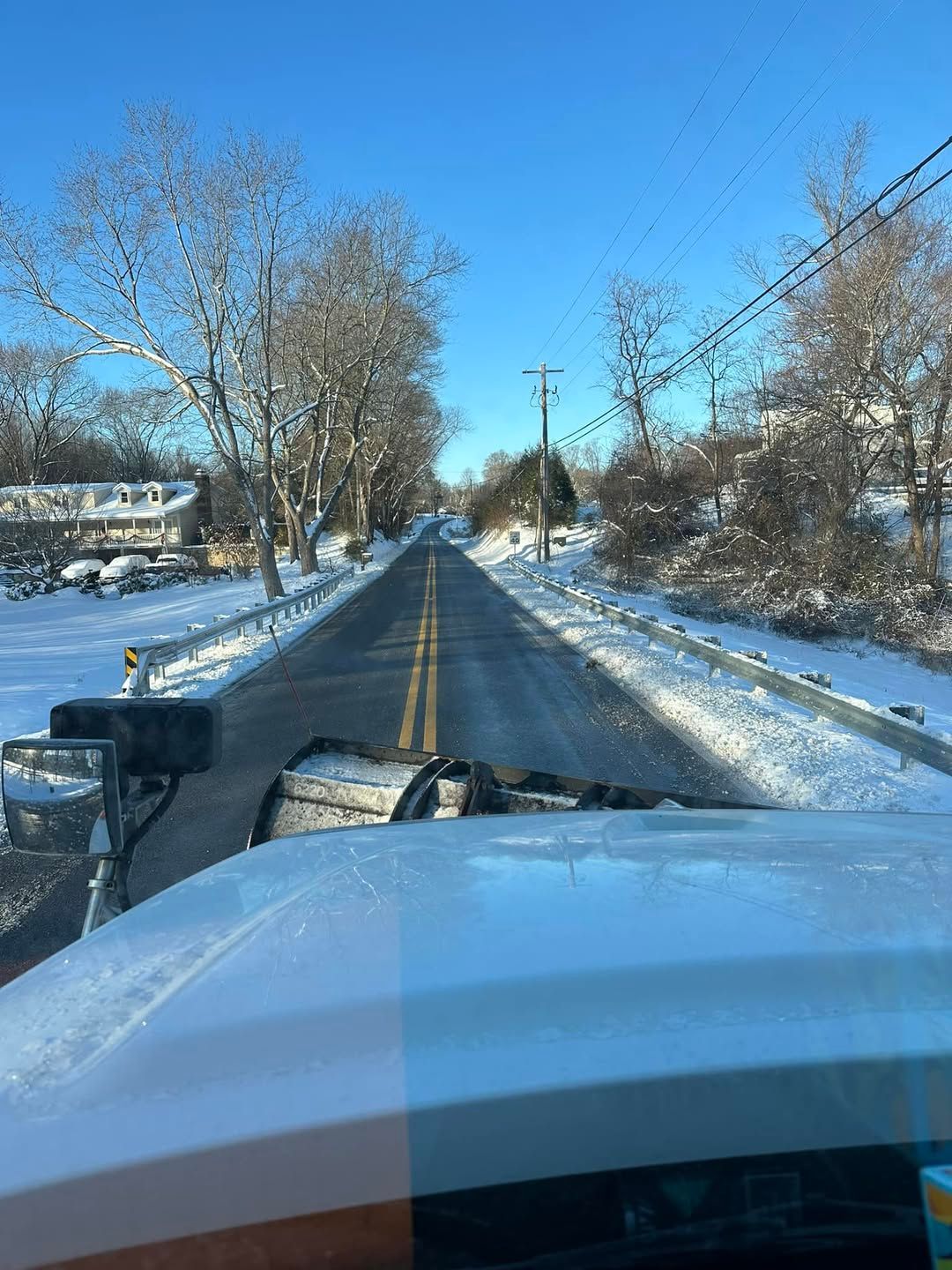 A truck is driving down a snowy road in Calvert County.
