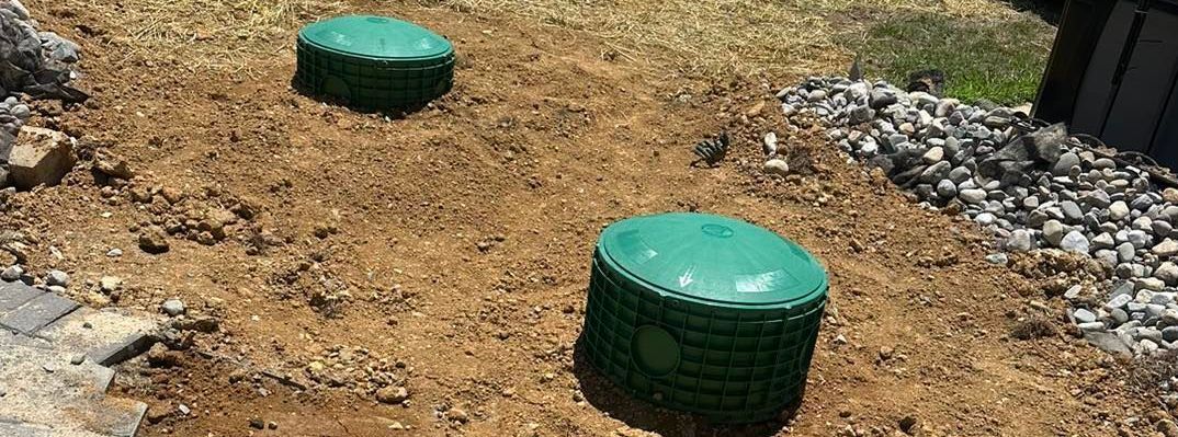 Two green ottomans are sitting on top of a pile of dirt.