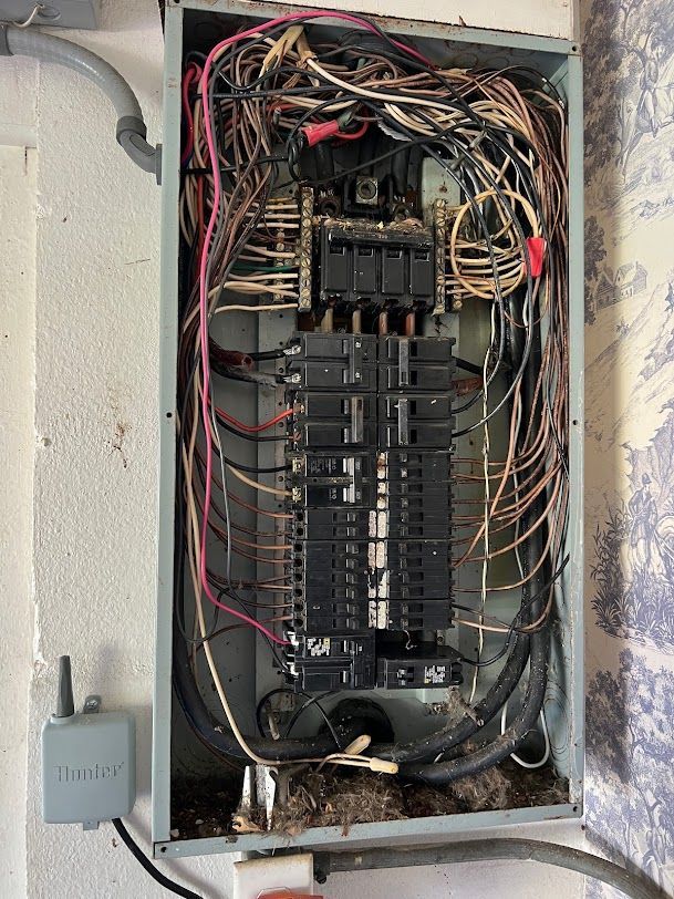 a very messy electrical box with a lot of wires coming out of it