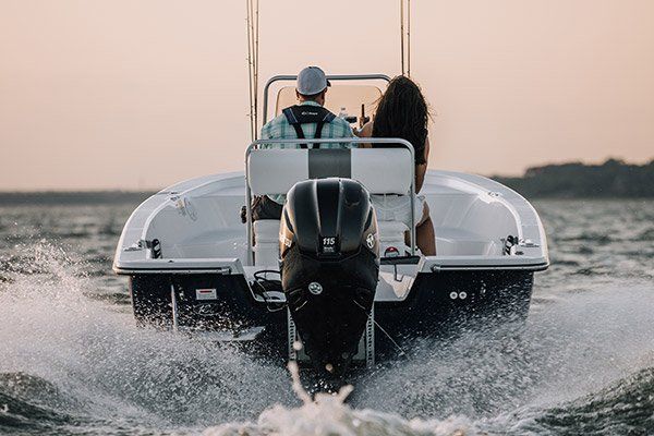 a man and a woman are riding a boat on a lake .