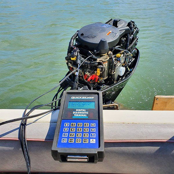 an outboard motor is being tested by a device on the side of a boat .