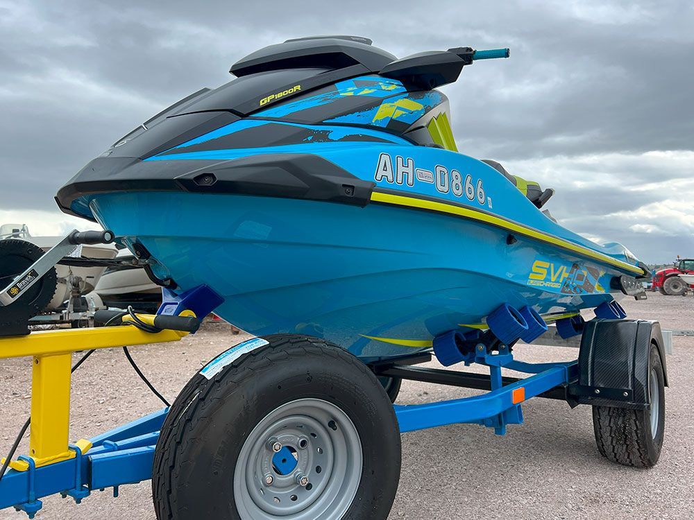 a blue jet ski is parked on a trailer .