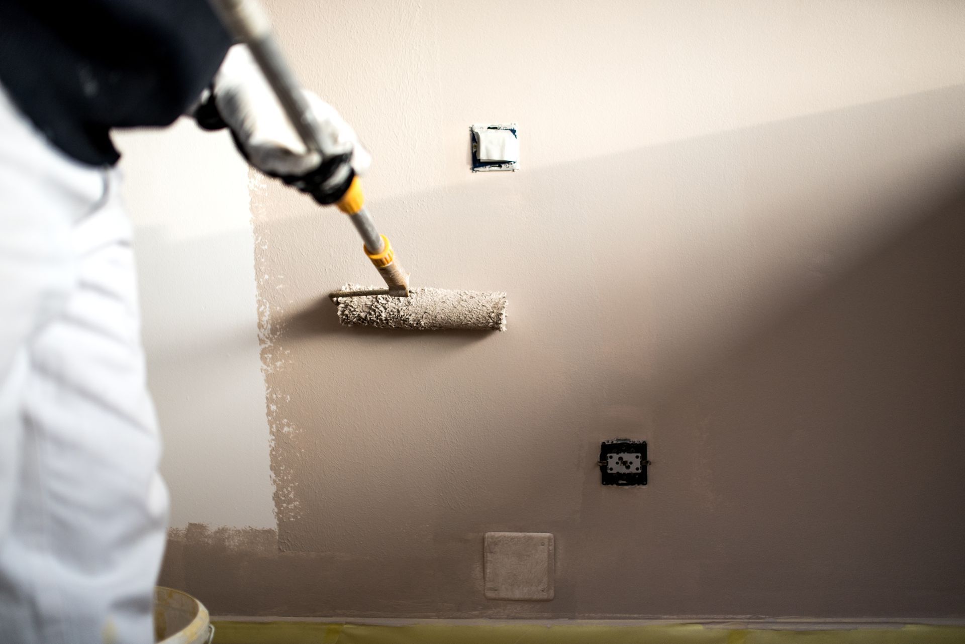 Handy man decorating walls with paint.