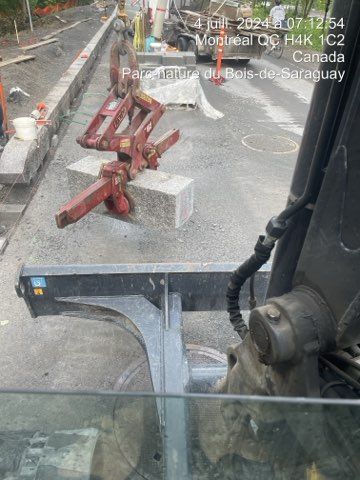 Un chantier de construction avec une machine soulevant un bloc de béton, Montréal, QC.