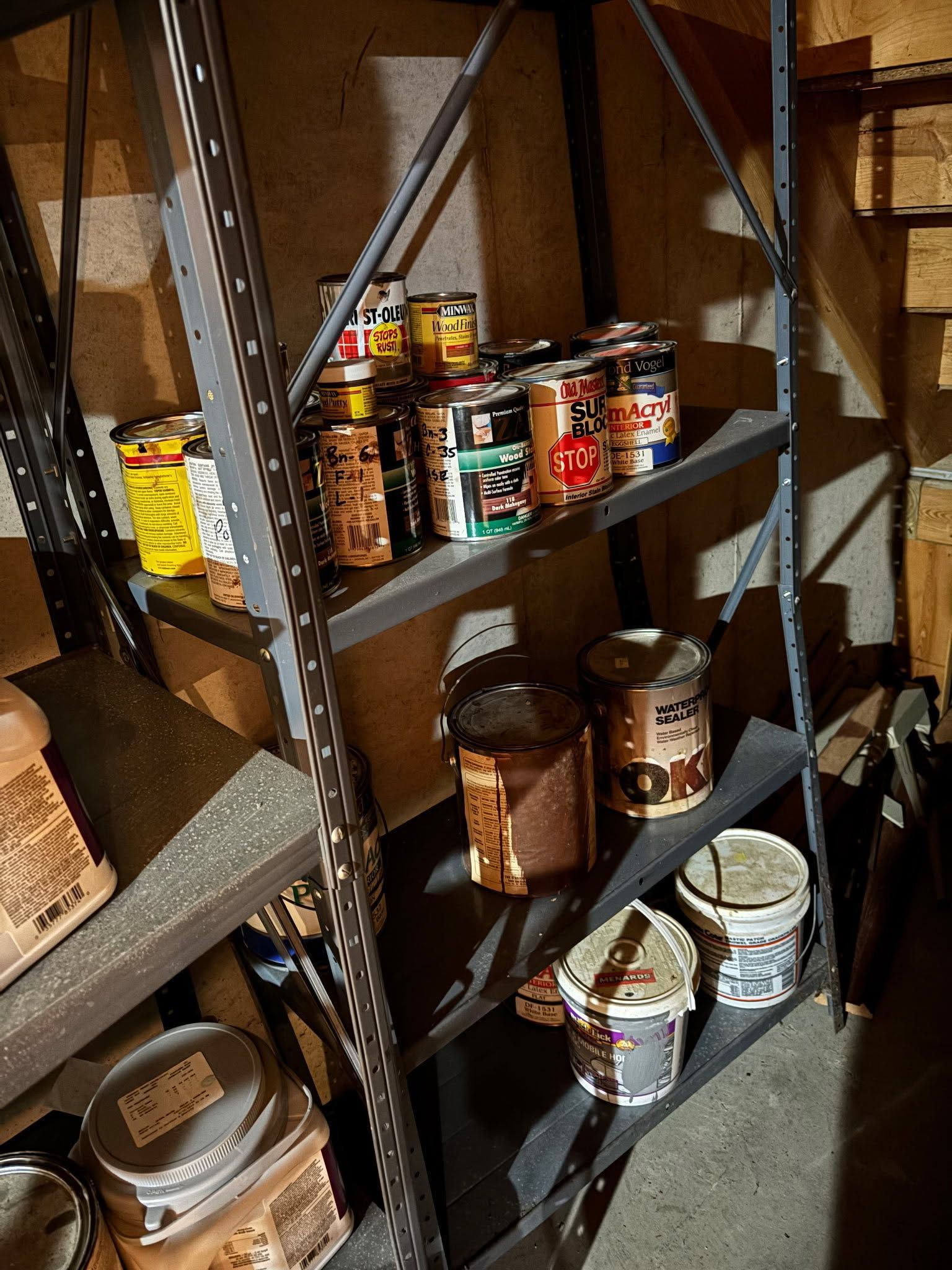 Metal pantry shelves lined with assorted canned and jarred food items in a storage closet