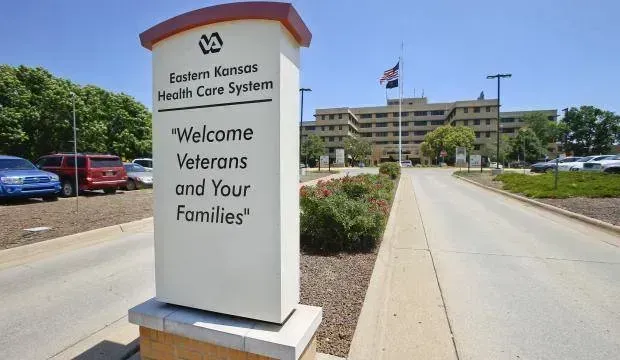 Wesley Medical Center sign at entrance to Veterans and Families; hospital building and parking lot behind