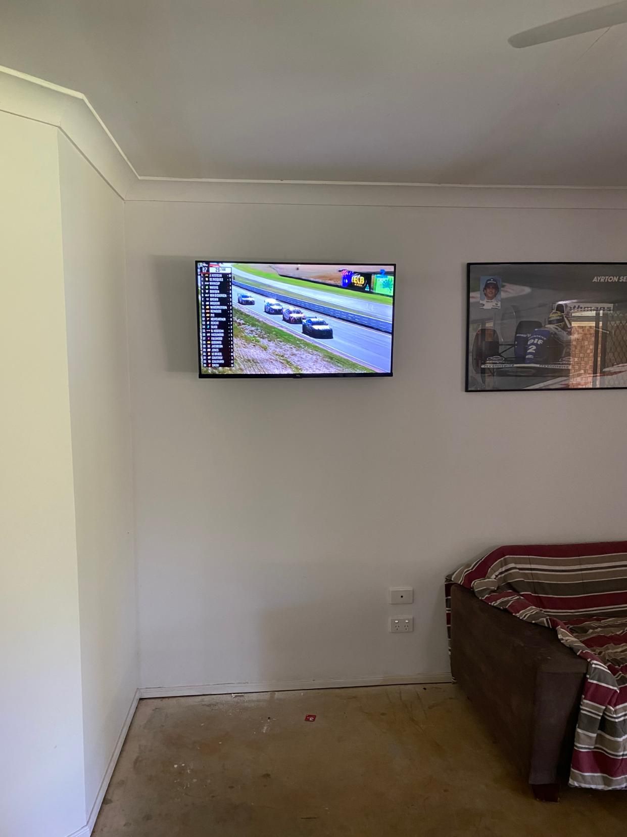 Flat Screen Tv is Hanging on a Wall in a Living Room — Brenden Wilson Electrical in Elimbah, QLD