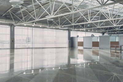 Empty modern airport terminal with glossy floor and exposed steel ceiling