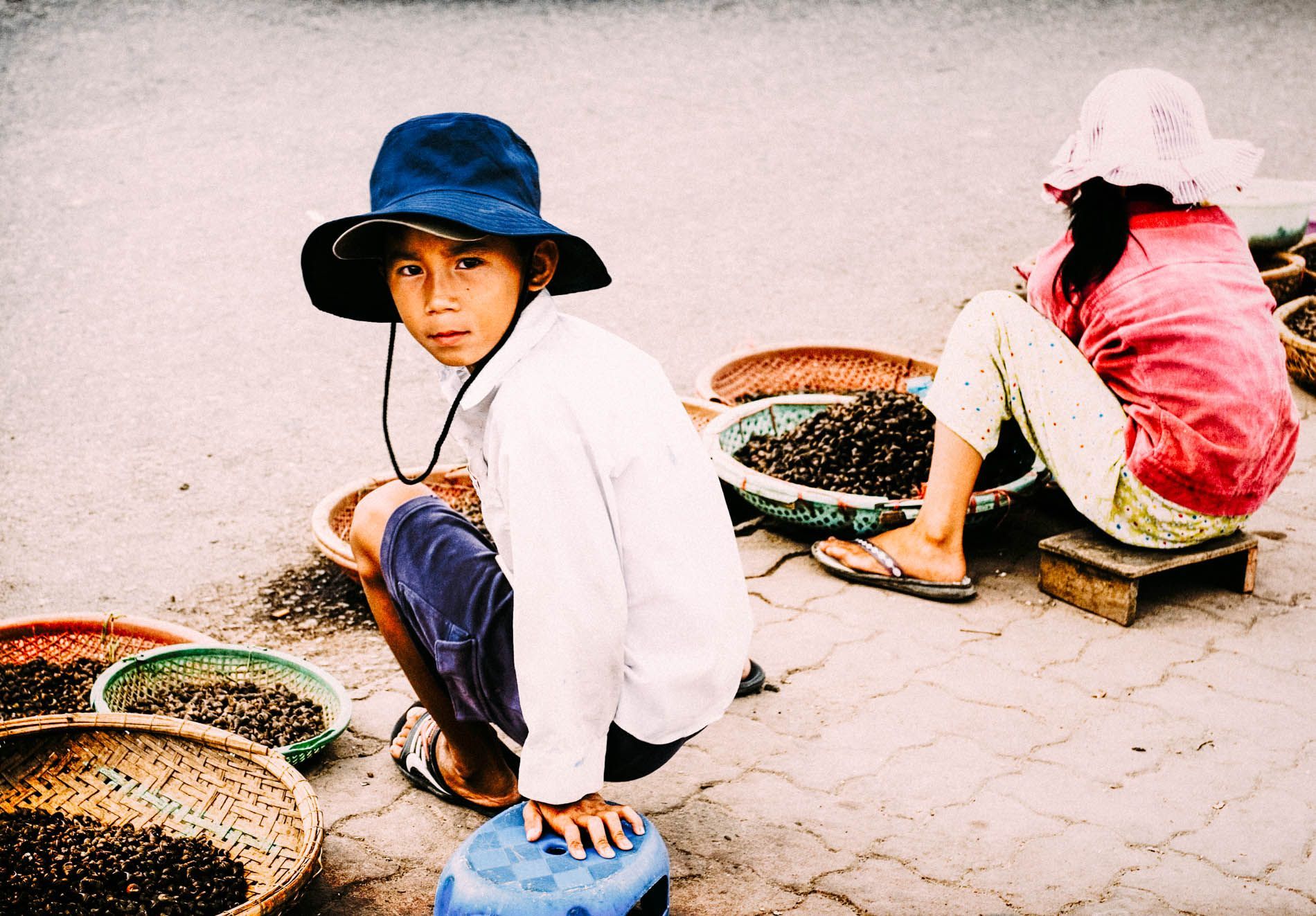 young boy selling snails roadside, Hue market, central Vietnam, small group travel and food photography tours with Sandlin Gaither Explorer's Club