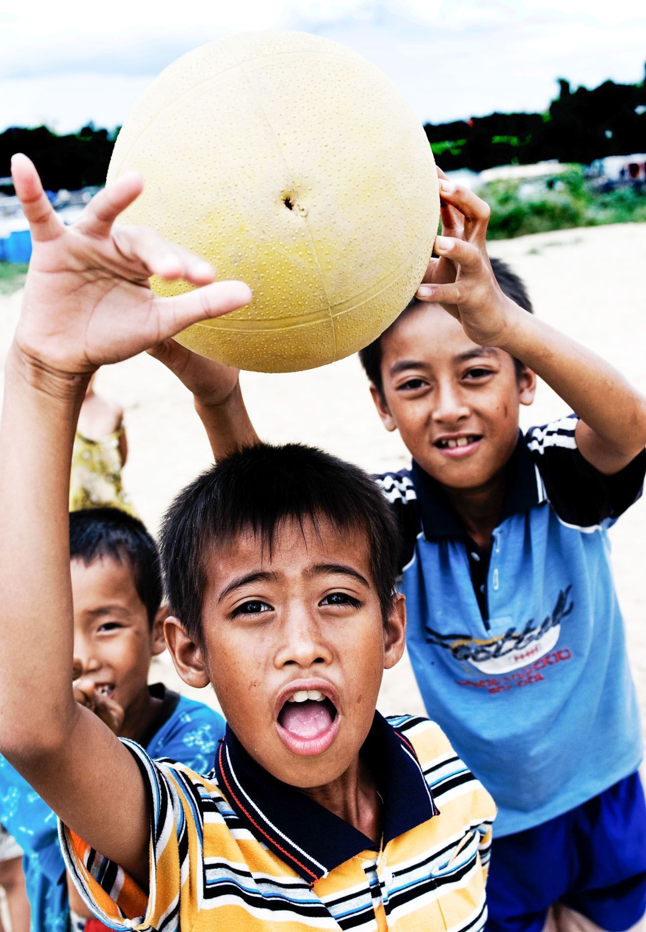 young boys playing soccer, smiling for the camera, Hue, Vietnam, small group travel and food photography tours with Sandlin Gaither Explorer's Club
